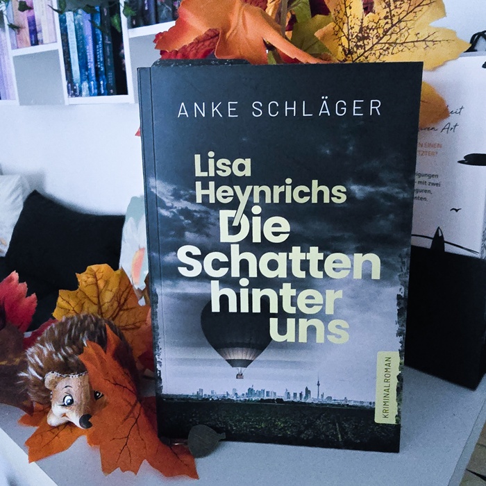 alt="Lisa Heynrichs: DIE SCHATTEN HINTER UNS"